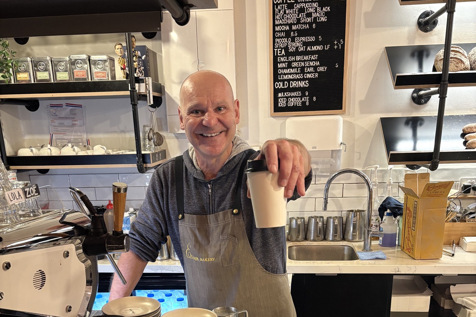 Mario, barista at Éclair Boulangerie, handing over a coffee